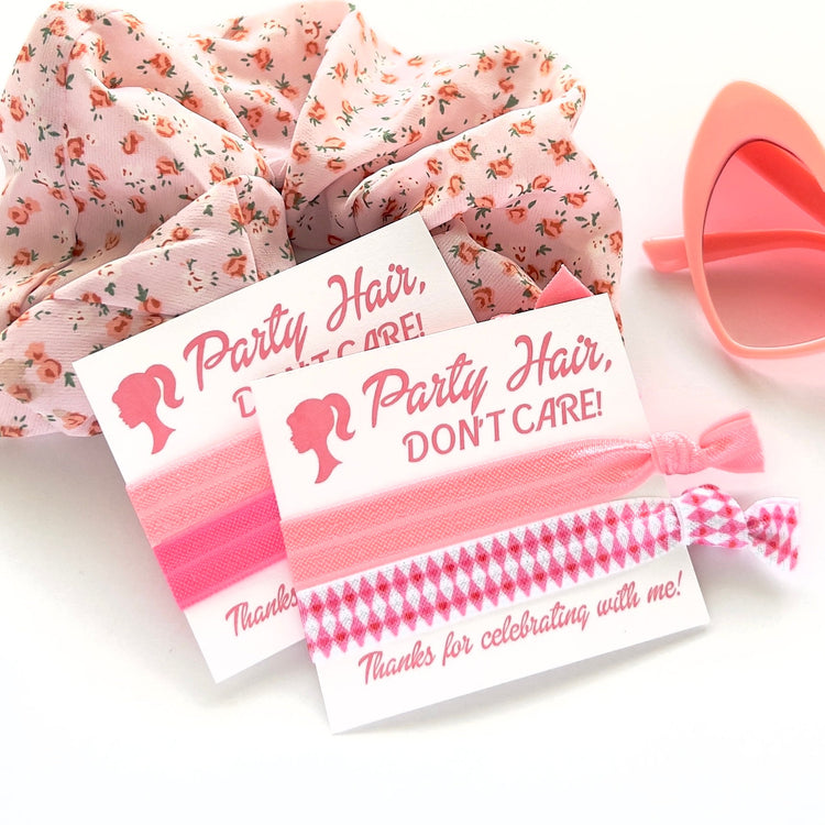 a pair of pink hair ties next to a pair of pink sunglasses