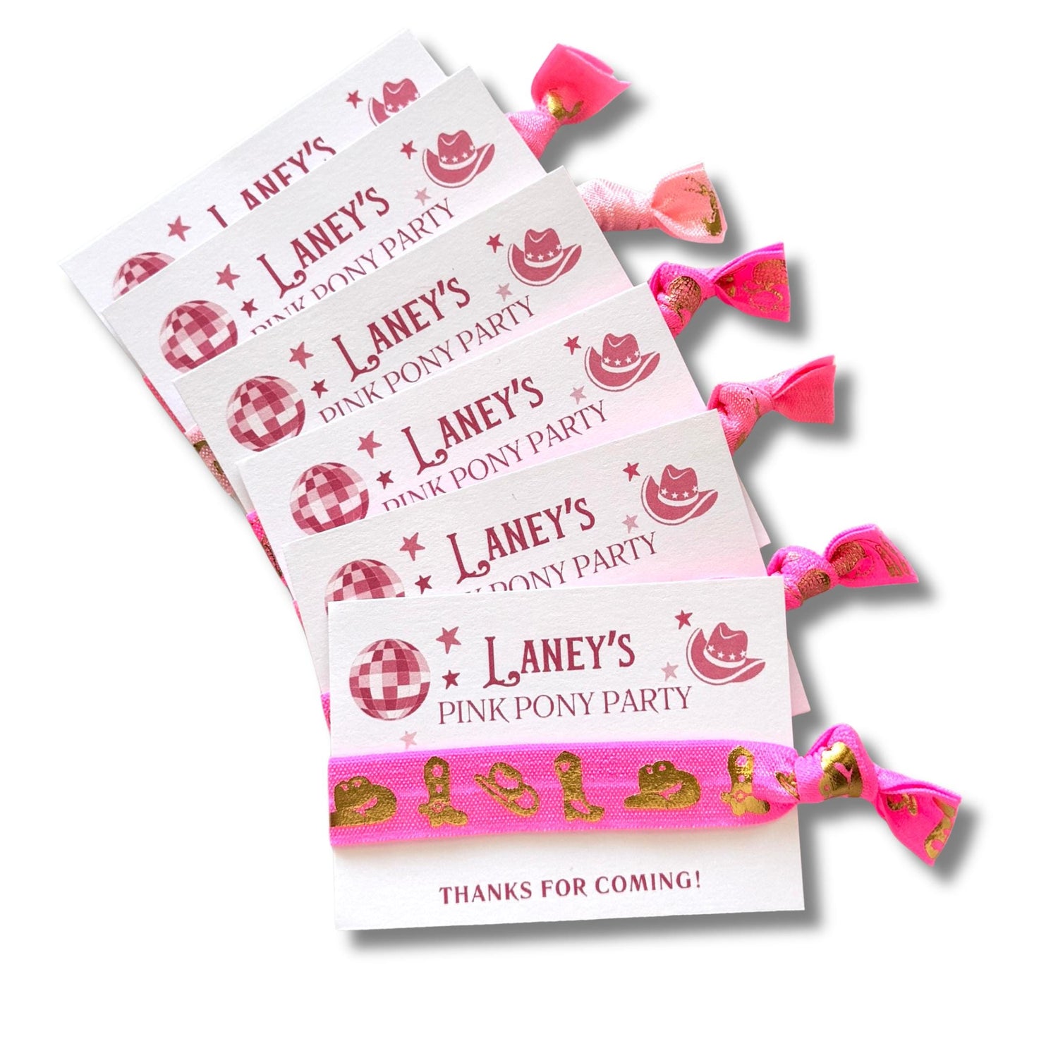 A set of pink hair ties with the text "Laney's Pink Pony Party" printed on them, along with a pink ribbon and a small image of a pink pony.